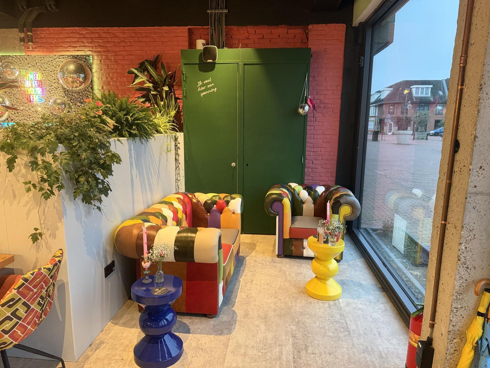 Lounge corner with colourful chesterfields by the window